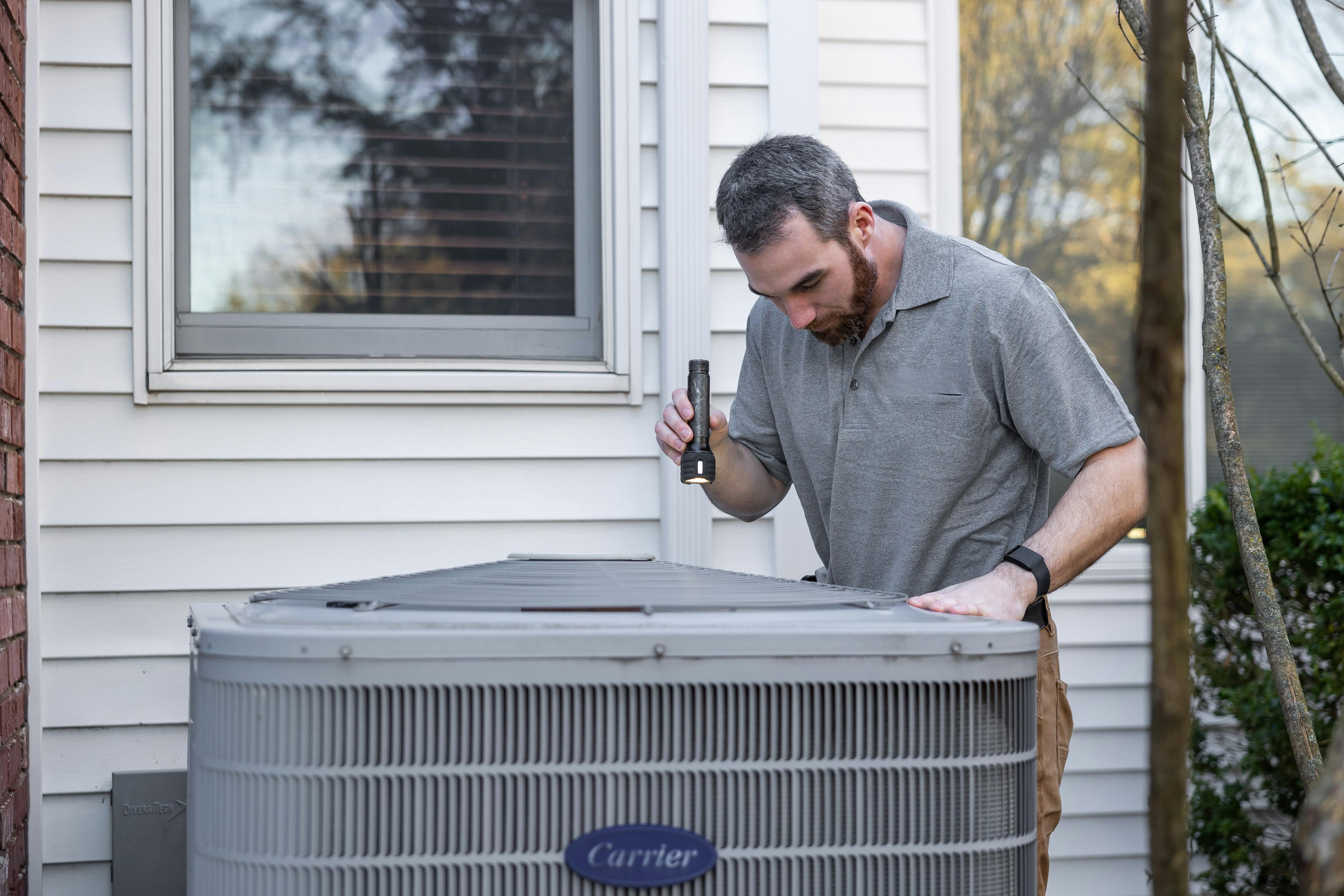 Technician servicing a home HVAC furnace